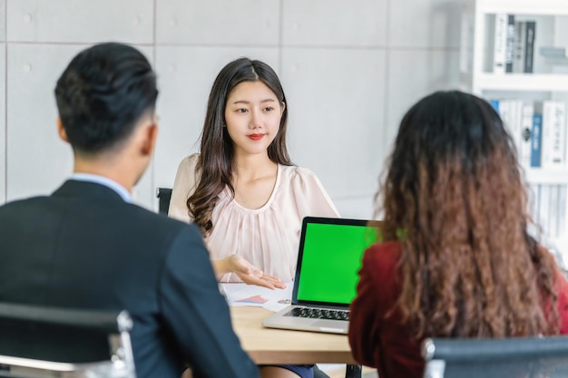 Người phụ nữ trẻ châu Á tốt nghiệp phỏng vấn với hai người quản lý qua bài thuyết trình